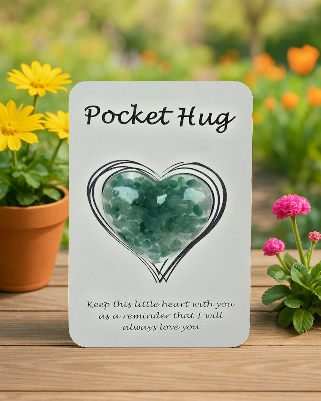 Card with definition of a 'Pocket Hug' surrounded by flowers on a wooden surface